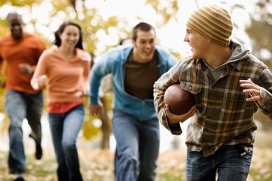 a-group-of-people-adults-and-young-people-playing-backyard-football-around-thanksgiving